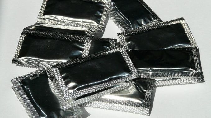Sølv kondomer ligge på hvidt bord
