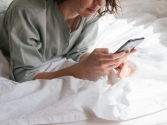 Kvinde bruger sin telefon i sin seng
